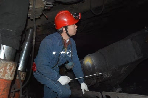 新铁煤矿采煤副总工程师穆岐春正在井下检查安全生产工作。袁晓松摄影